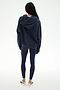 Standing with back to camera, the person is wearing the SPLITS59 Stella French Terry Oversized Hoodie in Indigo, paired with navy leggings and white sneakers against a plain white background.
