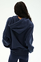 A person is seen from behind against a plain white background, wearing the Stella French Terry Oversized Hoodie in Indigo by SPLITS59 Los Angeles, paired with matching soft cotton leggings.