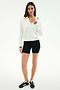 A woman faces forward against a plain white background wearing the SPLITS59 Taylor Knit Polo in White/Black.
