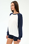 A woman wears the SPLITS59 Andie Oversized Colorblock Fleece in Indigo/White, paired with navy shorts, standing against a plain light background.