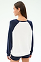 A woman with straight brown hair, seen from behind against a light background, wears the SPLITS59 Andie Oversized Colorblock Fleece in Indigo/White and black shorts.