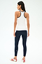A woman faces away, wearing the SPLITS59 Ashby Rib Tank in White/Indigo—ideal for yoga or gym—paired with navy blue leggings and white sneakers with red stripes, against a plain white background.