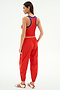 A woman faces away, wearing the SPLITS59 Kiki Rib Crop Tank in Lotus Red/Cobalt—perfect for gym workouts—with red track pants featuring white stripes and white Adidas sneakers with red accents.