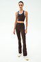 A woman poses in SPLITS59’s Raquel High Waist Supplex Flare in Dark Chocolate/Classic Blue, featuring 4-way stretch supplex—ideal for gym sessions—styled with a matching athletic crop top and white sneakers against a white background.