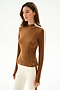 Woman wears the SPLITS59 Isabelle Airweight Lite Mock Neck - Toffee/Creme and white spandex leggings with a red stripe, standing against a plain white background.