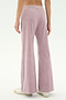 Person wearing SPLITS59 Joy Velour Pant in Blush and white sneakers, shown from the back against a plain light background.
