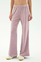 Model wears SPLITS59 Joy Velour Pant in Blush with white sneakers, standing against a plain light background. Upper torso is not visible.