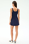A woman faces away from the camera, wearing the SPLITS59 Martina Rigor Color Block Dress in Indigo/Spearmint and white sneakers with blue stripes, set against a plain white background.