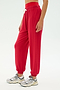A person wears the SPLITS59 Andie Oversized Fleece Sweatpant in Pirate Red with a crop top and gray sneakers, standing against a plain light background—ideal for cool-weather workouts in ultra-luxe fleece comfort.