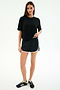 A woman stands facing forward in a black spandex t-shirt, SPLITS59 Megan Woven Nylon Run Short in Black/Creme, and black sneakers against a plain white background.