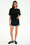 A woman stands facing forward in a black spandex t-shirt, SPLITS59 Megan Woven Nylon Run Short in Black/Creme, and black sneakers against a plain white background.