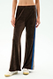 Model wearing the SPLITS59 Heritage Velour Pant in Dark Chocolate/Classic Blue, featuring ankle-length wide legs and blue and white side stripes, paired with white sneakers against a plain background.