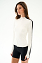 A woman wears the SPLITS59 Isabelle Airweight Lite Mock Neck - White/Black with black spandex shorts, standing against a plain white background.