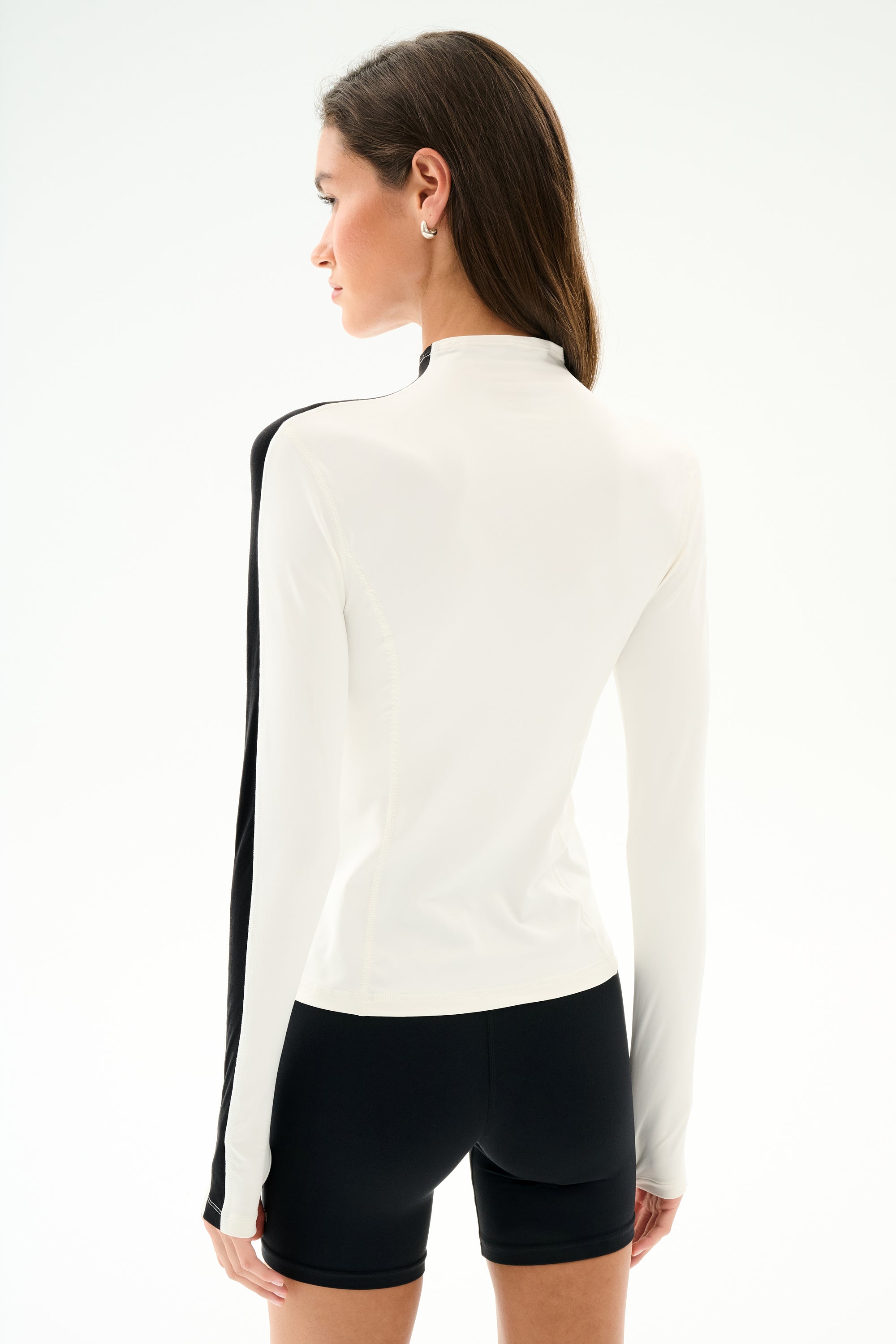 A woman with long brown hair models the SPLITS59 Isabelle Airweight Lite Mock Neck - White/Black, shown from the back against a plain white background.
