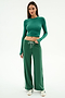 A woman wears the SPLITS59 Louise Rib Long Sleeve Crop in Arugula with matching wide-leg drawstring pants and white sneakers, standing against a plain white backdrop.