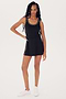A person with long hair stands in a black sleeveless Martina Rigor Dress w/Piping - Black by SPLITS59 and white sneakers, posing against a plain white background.
