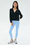 A woman stands against a plain background wearing the SPLITS59 Megan Woven Nylon Jacket in black, paired with light blue spandex leggings and silver athletic shoes.
