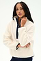 A woman with long braided hair wears the SPLITS59 Reese Sherpa Half Zip Pullover in Creme/Indigo, crafted from soft 100% polyester, featuring a navy zipper, as she poses against a plain white background.