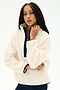 A woman with long braided hair wears the SPLITS59 Reese Sherpa Half Zip Pullover in Creme/Indigo, crafted from soft 100% polyester, featuring a navy zipper, as she poses against a plain white background.