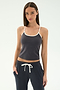 A woman in the SPLITS59 Airweight Tank - Graphite/White stands with her hands in her pockets, wearing matching drawstring pants and ready for Pilates against a plain background.
