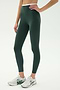 Someone wearing SPLITS59 Dual High Waist Airweight 7/8 leggings in Military/White stands against a plain light background with white athletic shoes.