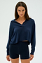 Person wearing the SPLITS59 Joan Fleece Polo Sweatshirt in navy with matching shorts, standing against a plain background.