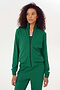 A woman warming up in a green Max Rigor track jacket and pants by SPLITS59.