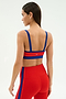 A woman wearing a SPLITS59 Monah Rigor Bra in Lotus Red/Cobalt with matching high-waisted leggings stands with her back to the camera against a plain background.