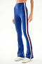Model wearing SPLITS59 Raquel High Waist Supplex Flare - Cobalt/Creme with white sneakers, shown from mid-torso down against a plain background.