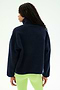 A person stands with their back to the camera, wearing the SPLITS59 Reese Sherpa Half Zip Pullover in Indigo/Limeade, paired with light green leggings, against a plain background.