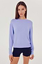 Front view of woman with dark brown hair wearing a light purple crewneck sweatshirt and black shorts