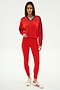 A woman wears the SPLITS59 Ellie Fleece V Neck Sweatshirt in Lotus Red/Cobalt, paired with red leggings and white sneakers with red stripes, standing against a plain white background.