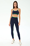 A woman faces forward wearing the SPLITS59 Eva Rigor Double Strap Bra in Indigo/Spearmint, paired with matching high-waisted leggings and white sneakers, set against a plain light background.