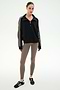 A woman stands against a plain background wearing the SPLITS59 Goldie French Terry Oversized Half Zip in Black/Lentil, featuring soft cotton fabric and striped sleeves, paired with taupe leggings and black sneakers.
