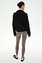 Wearing the SPLITS59 Goldie French Terry Oversized Half Zip in Black/Lentil, this person stands with their back to the camera, pairing the cozy cotton jacket with taupe leggings and black-and-white sneakers against a plain, light background.