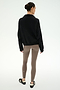 Wearing the SPLITS59 Goldie French Terry Oversized Half Zip in Black/Lentil, this person stands with their back to the camera, pairing the cozy cotton jacket with taupe leggings and black-and-white sneakers against a plain, light background.