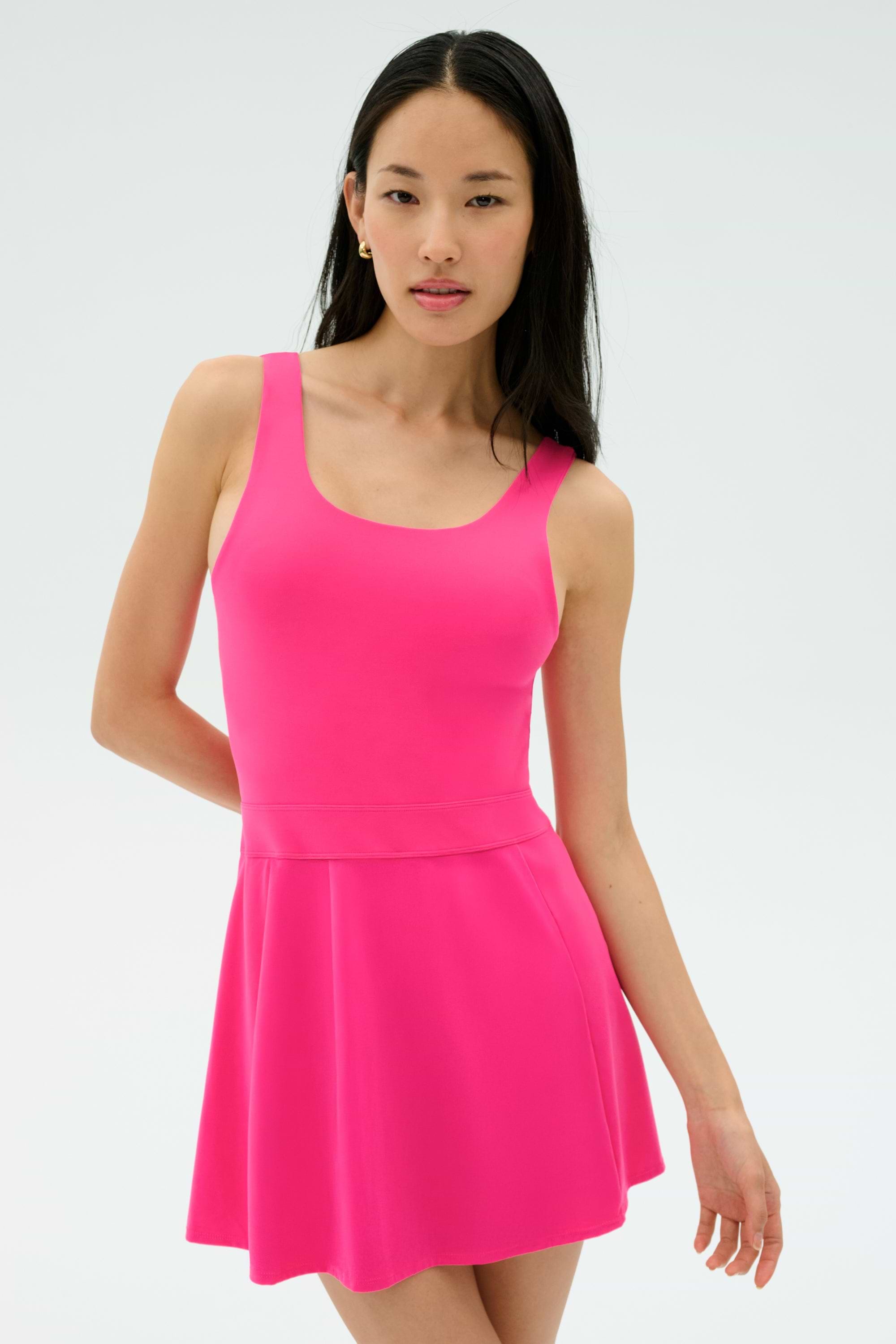 A woman wearing the SPLITS59 Martina Rigor Dress in Berry stands against a plain light background, looking at the camera.