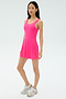 A woman stands against a plain background wearing the SPLITS59 Martina Rigor Dress in Berry and white sneakers with colorful accents.