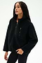 A woman wearing the SPLITS59 Reese Sherpa Half Zip Pullover in black, crafted from soft 100% polyester fleece and featuring a half-zip collar along with a zippered chest pocket, stands against a plain light background.