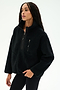A woman wearing the SPLITS59 Reese Sherpa Half Zip Pullover in black, crafted from soft 100% polyester fleece and featuring a half-zip collar along with a zippered chest pocket, stands against a plain light background.