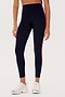A person wearing SPLITS59 Bianca High Waist Rigor 7/8 - Black leggings with a red stripe along the side and white sneakers.