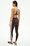 A woman faces away, wearing the SPLITS59 Bianca Rigor Bra in Dark Chocolate/White with matching high-waisted leggings featuring white stripes and brown sneakers, ideal for gym workouts, set against a plain white background.
