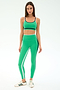 A woman wears SPLITS59's Sam High Waist Rigor 7/8 leggings in Spearmint/Indigo, paired with a matching sports bra and white sneakers, standing against a plain white background.