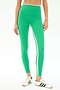 A person wearing SPLITS59 Sam High Waist Rigor 7/8 leggings in Spearmint/Indigo with a white stripe and white sneakers with green stripes stands against a white background.