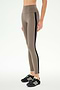 A person wearing SPLITS59 Margot Rigor Legging in Lentil/Black, featuring a taupe high-waisted design with a black side stripe and crafted from a comfortable nylon spandex blend, paired with black athletic shoes and standing against a plain white background.