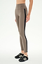 A person wearing SPLITS59 Margot Rigor Legging in Lentil/Black, featuring a taupe high-waisted design with a black side stripe and crafted from a comfortable nylon spandex blend, paired with black athletic shoes and standing against a plain white background.