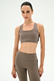 A woman models the SPLITS59 Lexi Rigor Bra in Lentil/Black, paired with matching activewear leggings made from stretchy nylon spandex fabric, standing against a plain white background and facing forward with a neutral expression.