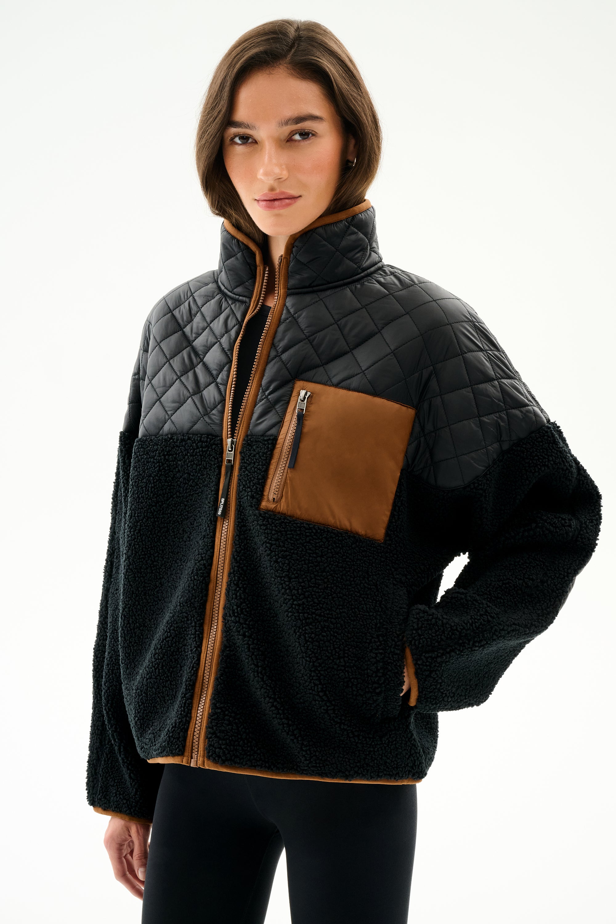 Person wearing the SPLITS59 Skylar Sherpa Jacket - Black/Toffee, a black and brown zip-up with high collar, made from 100% polyester, against a white background.