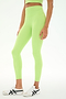 A person is wearing the SPLITS59 Sprint High Waist Rigor 7/8 leggings in Limeade, paired with a matching crop top and white sneakers with black stripes, standing against a plain white background.