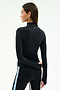 A woman faces away wearing the SPLITS59 Tess Rigor Half Zip Waist Length top in black and sleek black leggings with a light blue side stripe, set against a plain light background.